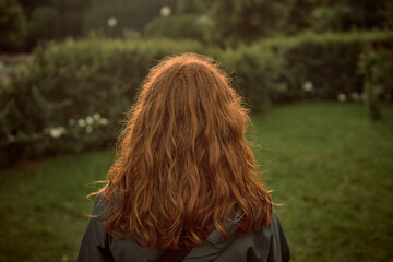 cinematic film red hair Pretty young girl back to camera, curly hair . travel summer view park...
