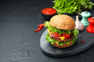 Delicious hamburger with patty served on black table. Space for text