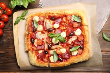 Tasty homemade pizza and ingredients on wooden table, flat lay