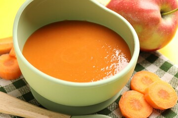 Baby food. Tasty puree in bowl and ingredients on table, closeup