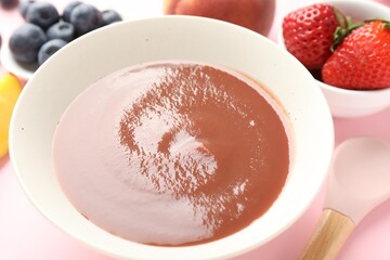Baby food. Tasty puree in bowl and ingredients on pink background, closeup