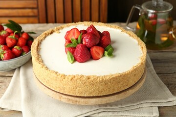 Tasty cheesecake with strawberries and mint on wooden table, closeup