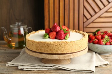 Tasty cheesecake with strawberries and mint on wooden table, closeup