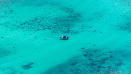 Aerial View of a Small Boat Floating in Turquoise Tropical Waters near Thailand