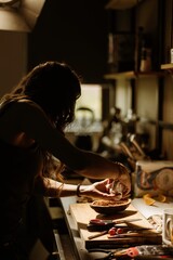 Pastry chef expertly arranges colorful ingredients to enhance cozonac, highlighting the delicate art of dessert decoration amidst a warm, inviting kitchen atmosphere
