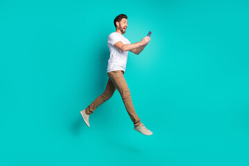 Young man enjoying technology interaction in a vibrant setting against a teal background