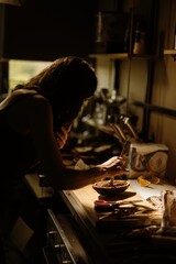A focused pastry chef artfully applies intricate decorations to cozonac in a warmly lit kitchen. Vibrant ingredients and baking tools enhance the traditional atmosphere
