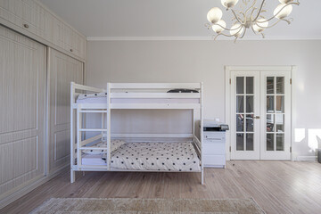 bright bedroom features a white bunk bed, a built-in wardrobe, and glass-paneled doors. Soft...