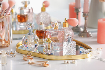 Bottles of different perfumes and accessories on dressing table indoors, closeup