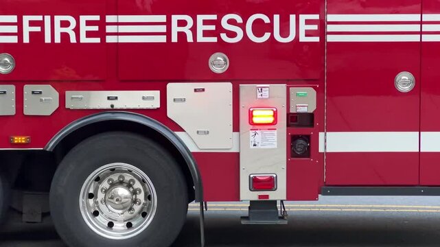Looping close up of a red fire engine and rescue truck with flashing lights