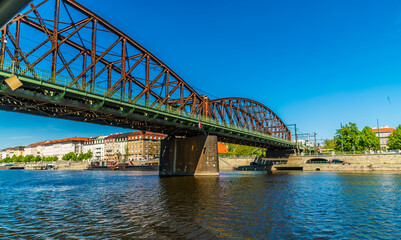 A view from the Vltava river passing under the Vysehrad Railway Bridge in Prague in springtime