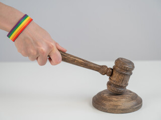 Judge with rainbow bracelet hits gavel. 