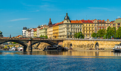 A view from the Vltava river towards river traffic passing under the Palacke bridge in Prague in springtime