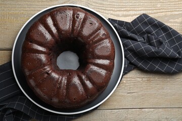Tasty chocolate bundt cake on wooden table, top view