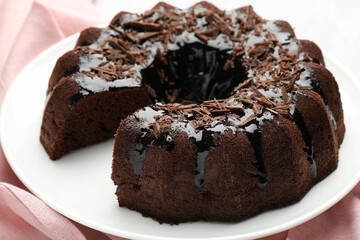 Delicious chocolate bundt cake and napkin on table, closeup