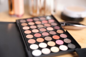Different makeup products on wooden vanity indoors, closeup