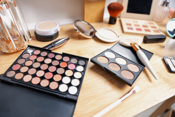 Different makeup products on wooden vanity indoors, closeup