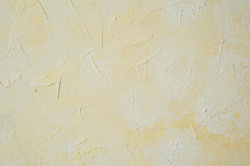 Textured yellow wall with plaster pattern and warm decorative effect