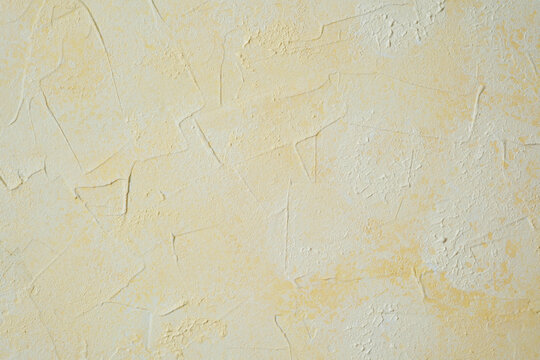 Textured yellow wall with plaster pattern and warm decorative effect