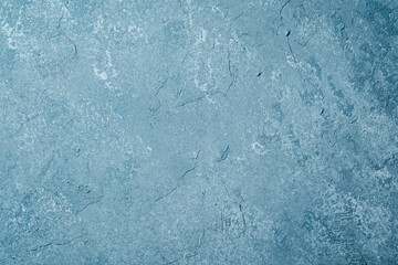 Grunge blue plaster wall with weathered texture and mottled pattern