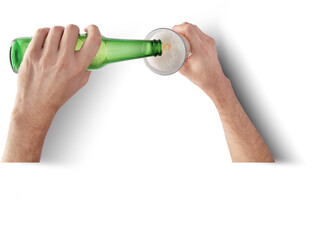 A person pouring a beverage from a green bottle into a glass, creating a frothy head.