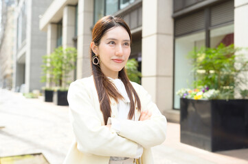 腕を組んで自信に満ちた表情を見せる若い女性のポートレート