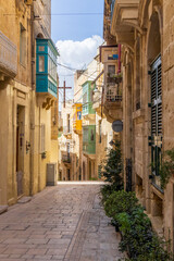 Malta, Birgu. Narrow street with stone buildings.