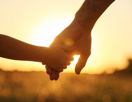 Silhouette of Adult and Child Holding Hands in Nature During Golden Hour, sunset