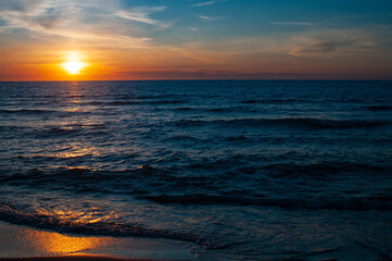 Beautiful colorful sunset in cloud sky at tranquil sea