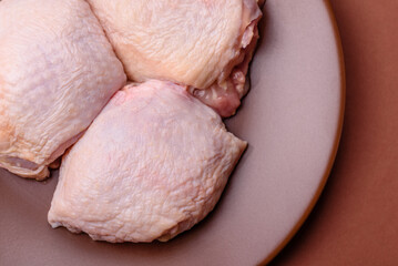 Meat, raw chicken thigh, leg in skin with salt and spices. Raw chicken thigh
