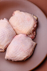 Meat, raw chicken thigh, leg in skin with salt and spices. Raw chicken thigh