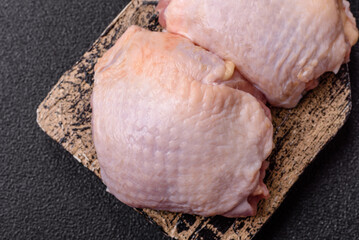 Meat, raw chicken thigh, leg in skin with salt and spices. Raw chicken thigh