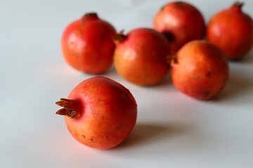 Pomegranate. Fresh fruits on a white surface, highlighted in soft light