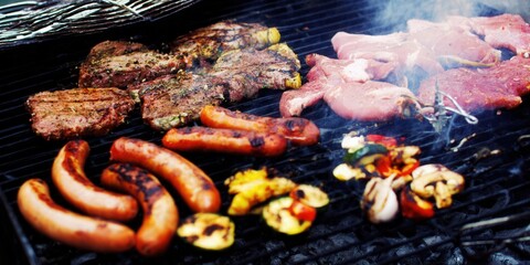 A barbecue grill sizzling with steaks, sausages, and fresh vegetables, perfect for a summer cookout.