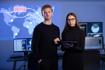 Professional and confident cyber security team in front of dark cybersecurity SIEM system with logs...