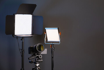 Professional lighting equipment and camera on color background. Space for text