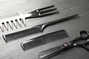 Different barber's tools on black table, closeup