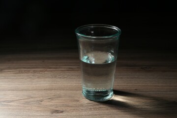 Fresh water in glass on wooden table