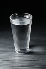 Fresh water in glass on dark wooden table