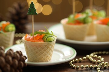 Tasty canapes and festive decor on wooden table against blurred lights, closeup. Bokeh effect