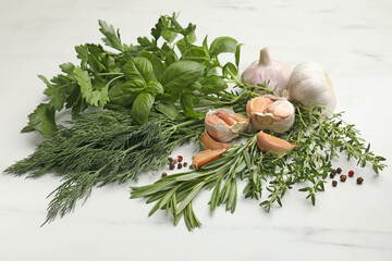 Different fresh herbs and spices on white table