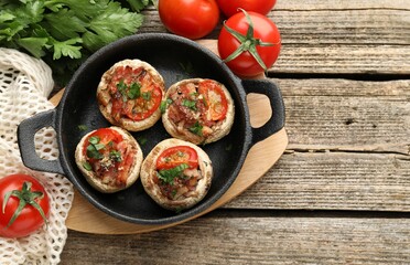 Tasty stuffed mushrooms served on wooden table, flat lay. Space for text