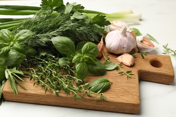 Different fresh herbs and spices on white table, closeup