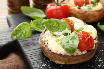 Tasty stuffed mushrooms served on wooden table, closeup