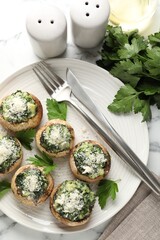 Tasty stuffed mushrooms served on white table, flat lay