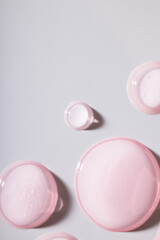 pink drops of oil, pink gel swatch, cosmetic textures, skincare product sample