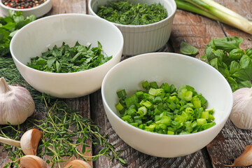 Different fresh herbs and spices on wooden table, closeup