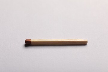 One match with brown head on grey background, closeup