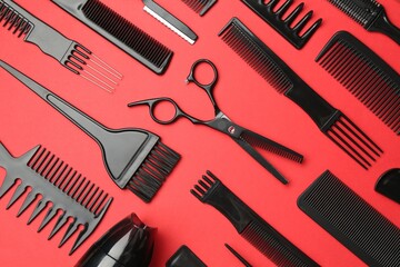 Different hairdresser's tools on red background, flat lay