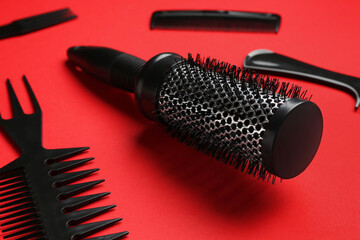 Different hairdresser's tools on red background, closeup